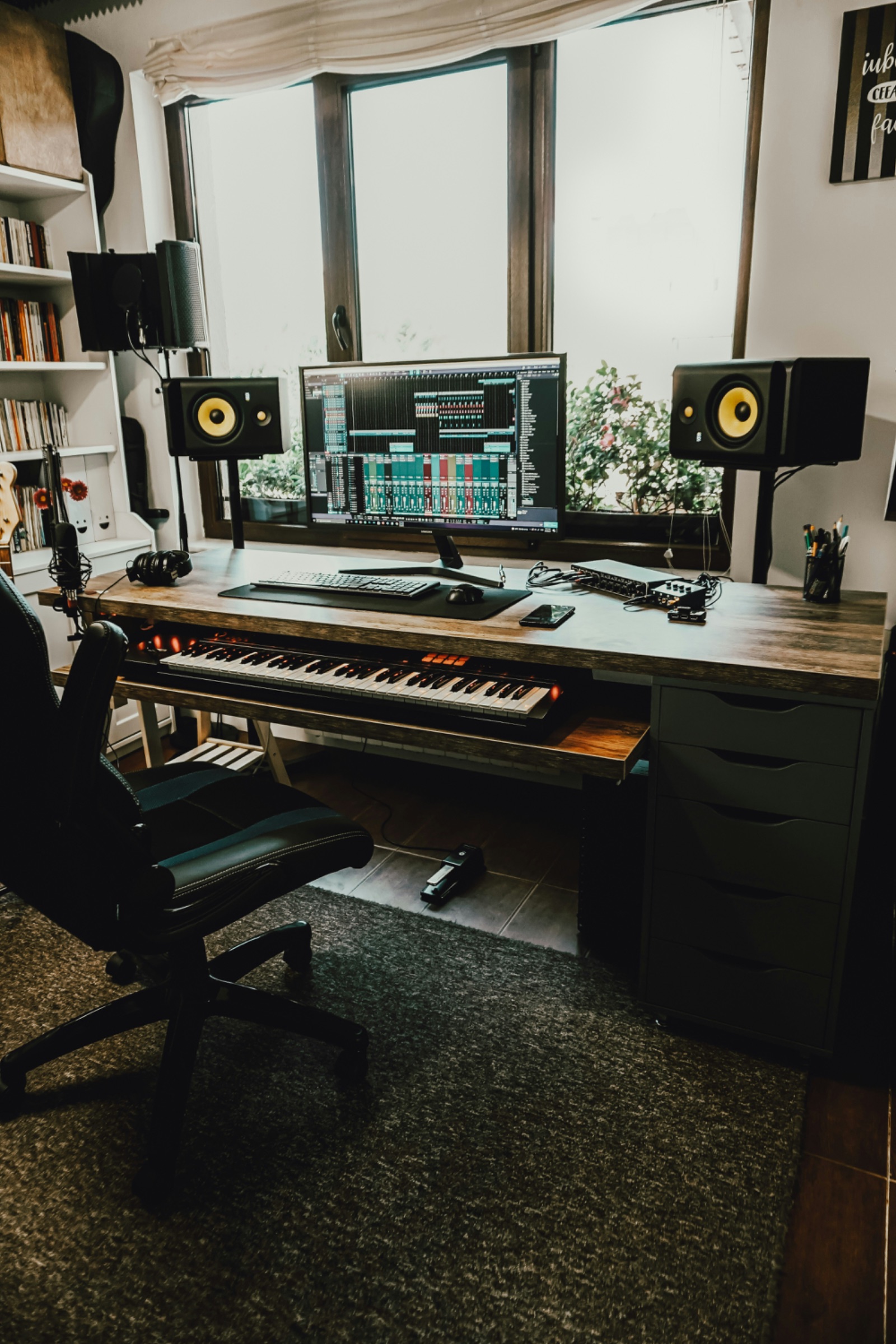 Home recording studio desk with DAW, monitors and MIDI keyboard